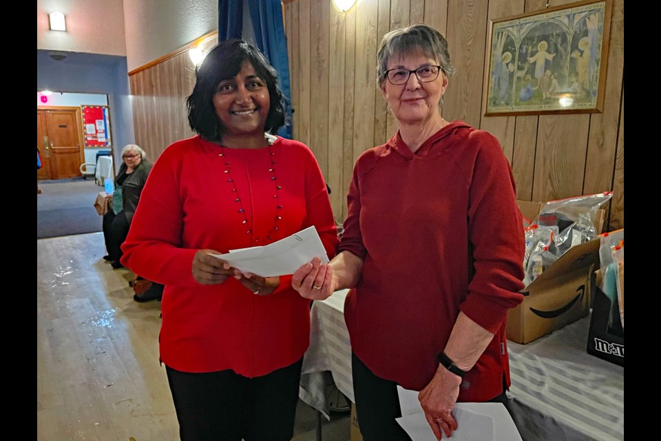 Sue Haddow, donations coordinator for the Innisfail Christmas Bureau (left), receives a $1,000 donation on Nov. 23 from Hazel Ray, people’s warden for St. Mark’s Anglican Church. Haddow said her agency still needs new gifts for teenagers. Johnnie Bachusky/MVP Staff