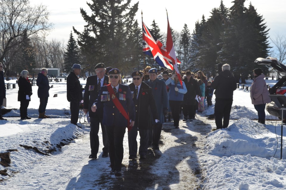 The colour party marches toward the cenotaph.