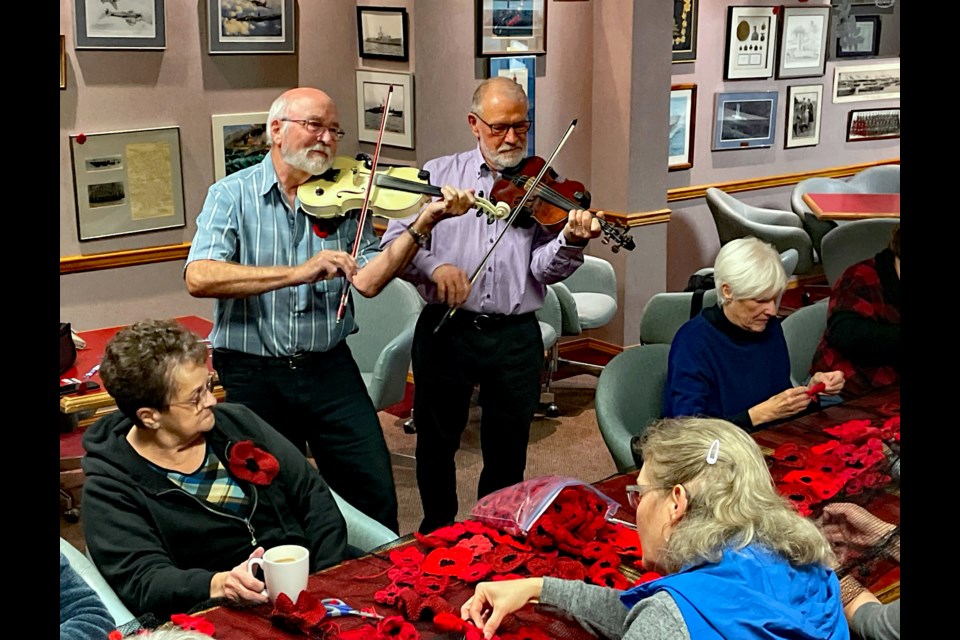 Local fiddlers Murray Cameron and Brian Jackson play away to entertain volunteers helping with the Crochet Poppy Project campaign on Nov. 2 by making a special Remembrance Day curtain with up to 1,800 total crocheted poppies. Johnnie Bachusky/MVP Staff 