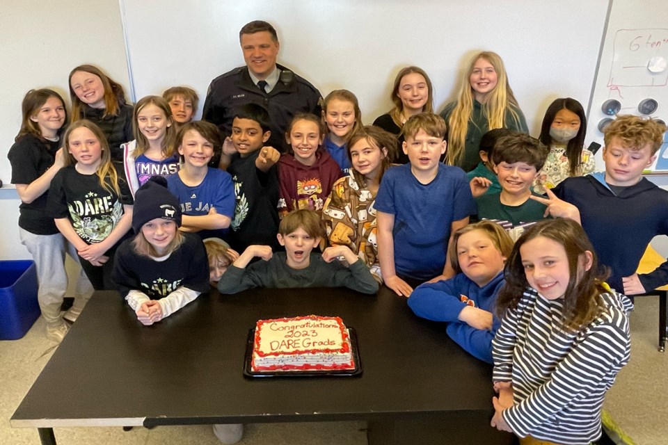 Innisfail RCMP Const. Craig Nelson, the detachment's community schools resource officer, with the D.A.R.E. Grade 5 graduating class at St. Marguerite Bourgeoys Catholic School on March 22. Johnnie Bachusky/MVP Staff
