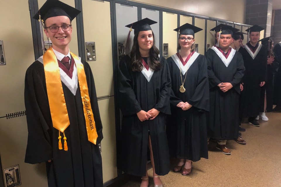 Valedicatorian Brandon Holliday, left, shares a smile with fellow graduates on Friday.