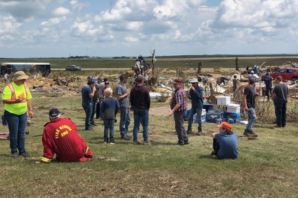 Volunteers take a break for lunch surrounded by the shattered remains of a farm along Highway 2A in Mountain View County following the Canada Day tornado.
Dan Singleton/MVP Staff