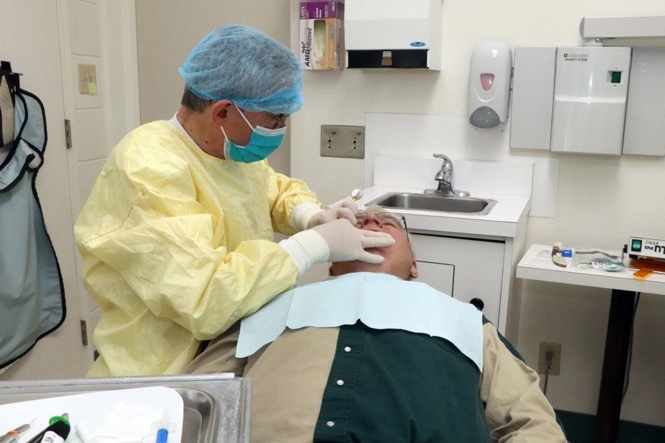 Innisfail's Dr. Clifford Tym works on Ponoka's Raymond Smith on Dec. 10. Smith was Tym's last patient in his 53-year dental career. 
Johnnie Bachusky/MVP Staff