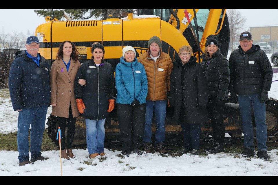 People involved in creation of Kirsten’s Place, an emergency shelter for people who’ve suffered domestic violence, pose in front of a backhoe after it officially moved dirt for construction of the shelter during a ceremony May 1. From left: Mountain View Emergency Shelter Society president Joe Carignan; director Letitia Gole; vice-president Raelynn Notley; director Roberta Hammer; secretary/treasurer Bill Johnston; director Carol Johnston; director in charge of Fundraising Dale Rosehill; and director Bob Phillips. Missing: director Russ Pouliotte. Photo by Doug Collie/MVP Staff