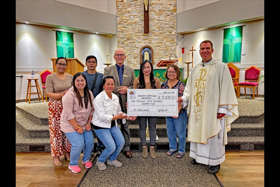 Members of Innisfail's Phil-Can Neighbourhood Association and the Innisfail Knights of Columbus gather alongside Father Curtis Berube at Our Lady of Peace Catholic Church on June 22 for a cheque presentation of $4,875. The money will go towards purchasing 25 wheelchairs for Filipino citizens in the Philippines. Johnnie Bachusky/MVP Staff