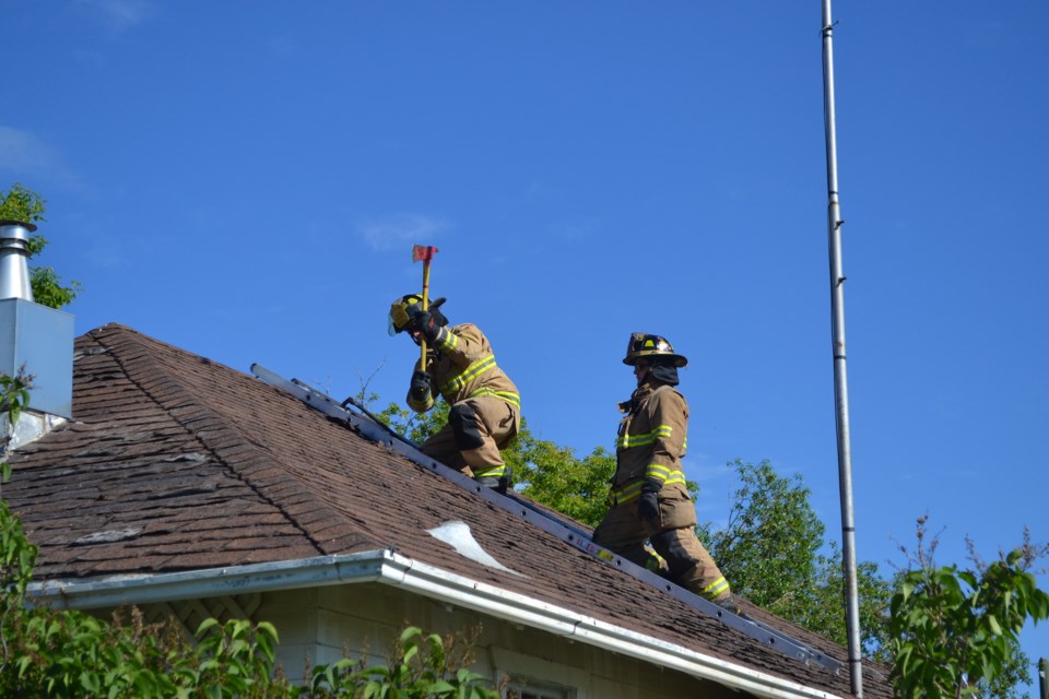 Firefighters practised chopping a hole in the roof for ventilation at an abandoned house during a fire training exercise at the Olds Regional Exhibitioin grounds.