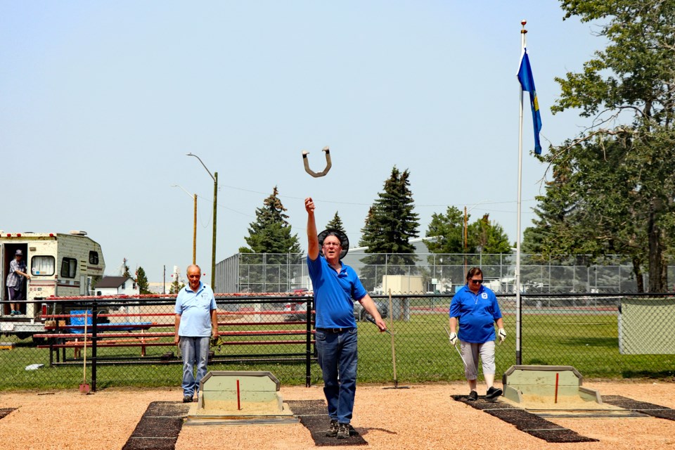An Innisfail Open competitor throws a horseshoe during play at the annual tournament on July 8 under the Alberta flag. The decision by the Innisfail and District Horseshoe Club to fly the provincial flag alone on the club's flag pole has raised objections with some members of town council who say it violates town policy. Johnnie Bachusky/MVP Staff