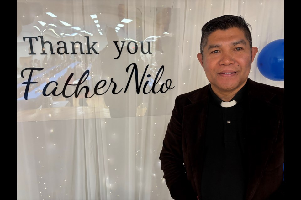 Father Nilo Macapinlac poses by one of the decorations in his honour during a farewell gathering May 19.
Doug Collie/MVP Staff