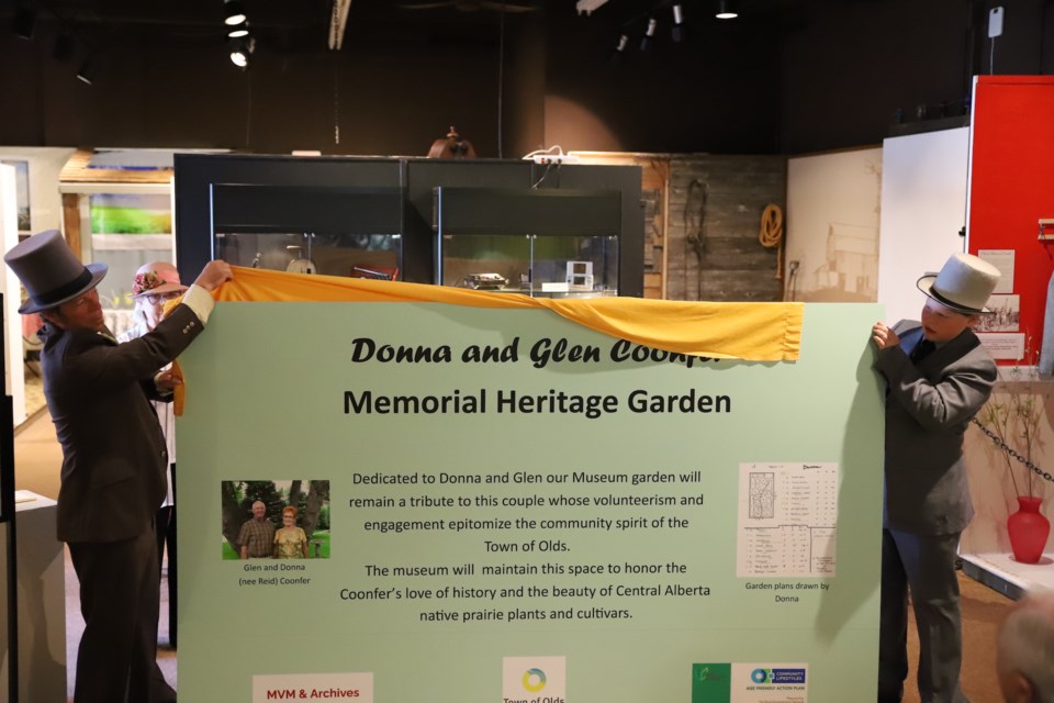 Volunteer James Edwards, left and his son Llewlyn unveil the sign for the Donna and Glen Coonfer Memorial Heritage Garden.