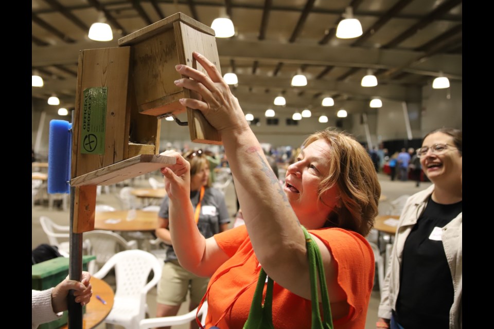 After figuring out to flip it upside down, Linda Granda 4 four of High Prairie opens a geocache in the Cow Palace.
Doug Collie/MVP Staff