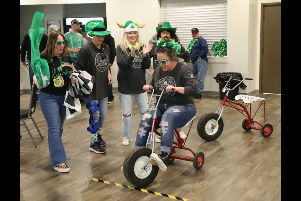 Jade Prefontaine throws the flag to start a racer during the second annual Bowden tricycle races, held March 16 at the Paterson Community Centre.