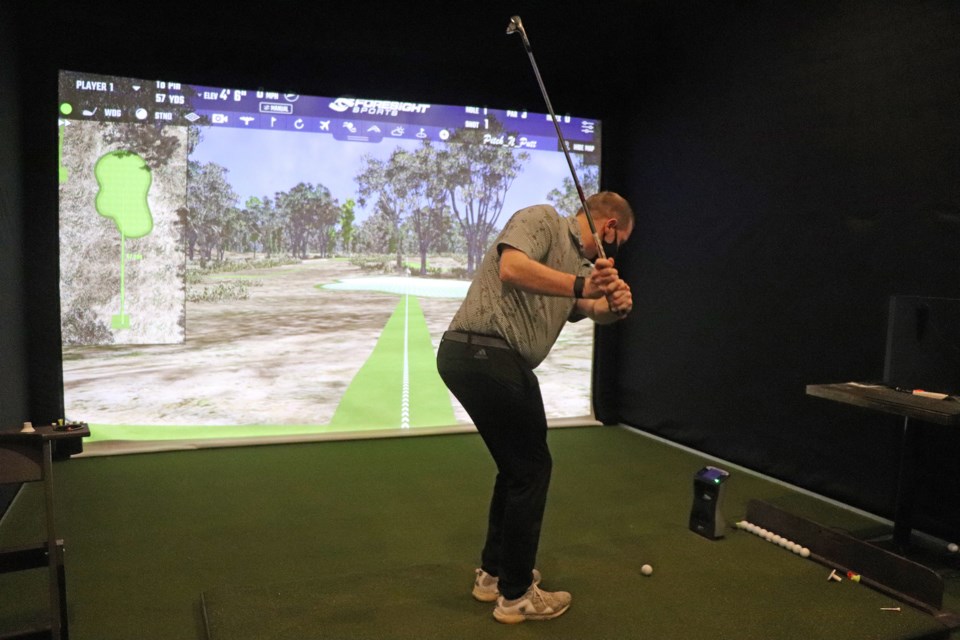 Mathew MacDonald, head pro at the Innisfail Golf Club, takes a practice shot on the club's new Foresight GC Quad simulator. 