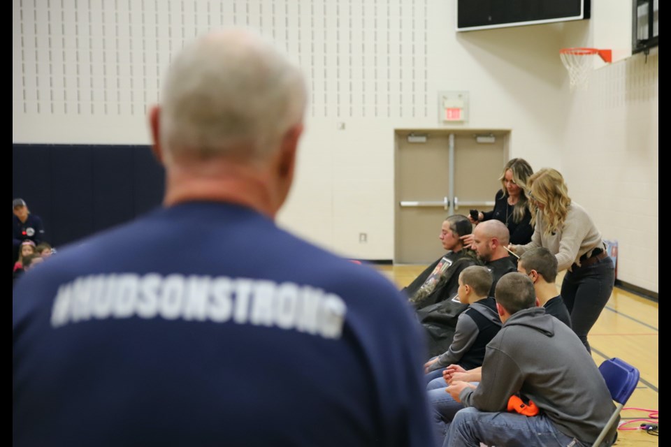 His head already shaved, a member of the family, wearing a #HUDSONSTRONG T-shirt, watches as Tiffany and Joe Faught get their heads shaved.
Doug Collie/MVP Staff