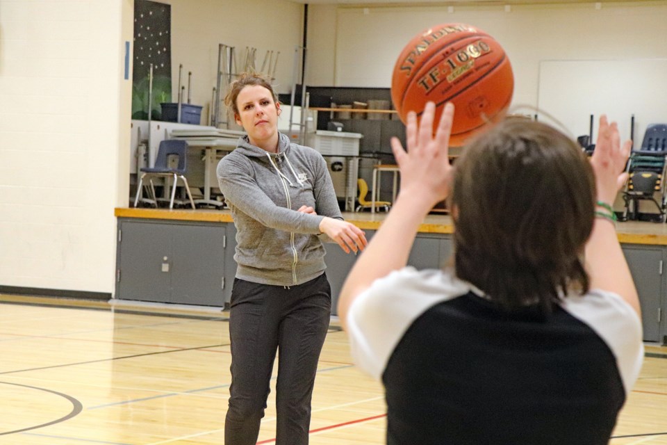 Teacher Chelsea Wilson practices a drill with a young student and senior boys basketball player at St. Marguerite Bourgeoys Catholic School on Feb. 1. The seniors boys team will soon be playing in the second annual St. Marguerite Growler Basketball Tournament on Feb. 10 and 11. Johnnie Bachusky/MVP Staff