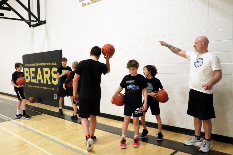 Stefan Labrecque, the principal and coach of the senior boys Bears basketball team at St. Marguerite Bourgeoys Catholic School, directs his young players during a series of practice drills on Feb. 1. Johnnie Bachusky/MVP Staff