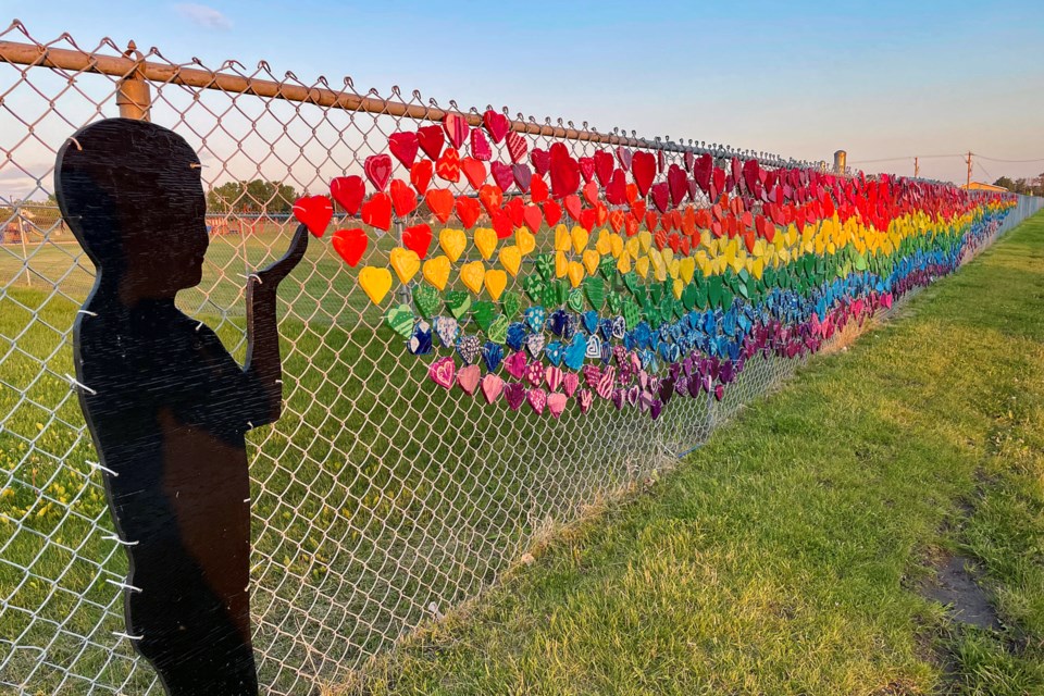 The recently completed heart mural on the chain link fence along 52nd Avenue begins with a silhouette child blowing out a heart, which instantly multiplies until fading after 112 feet. Johnnie Bachusky/MVP Staff