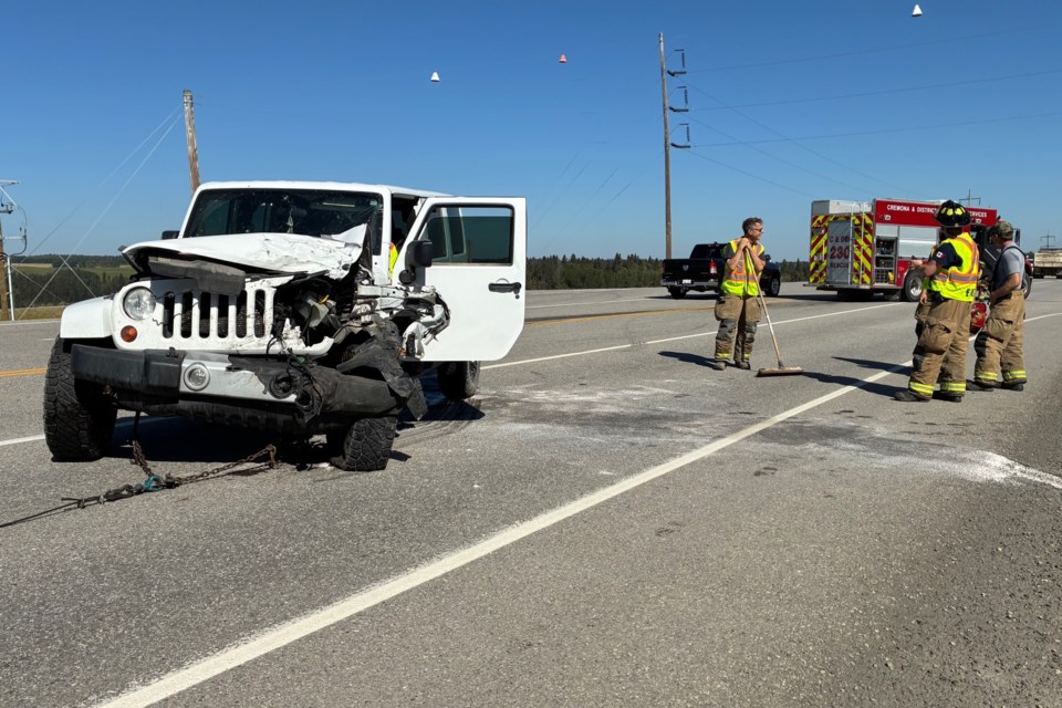 Emergency crews clean up debris following a two-vehicle crash on Highway 22 southeast of Sundre on Sunday.