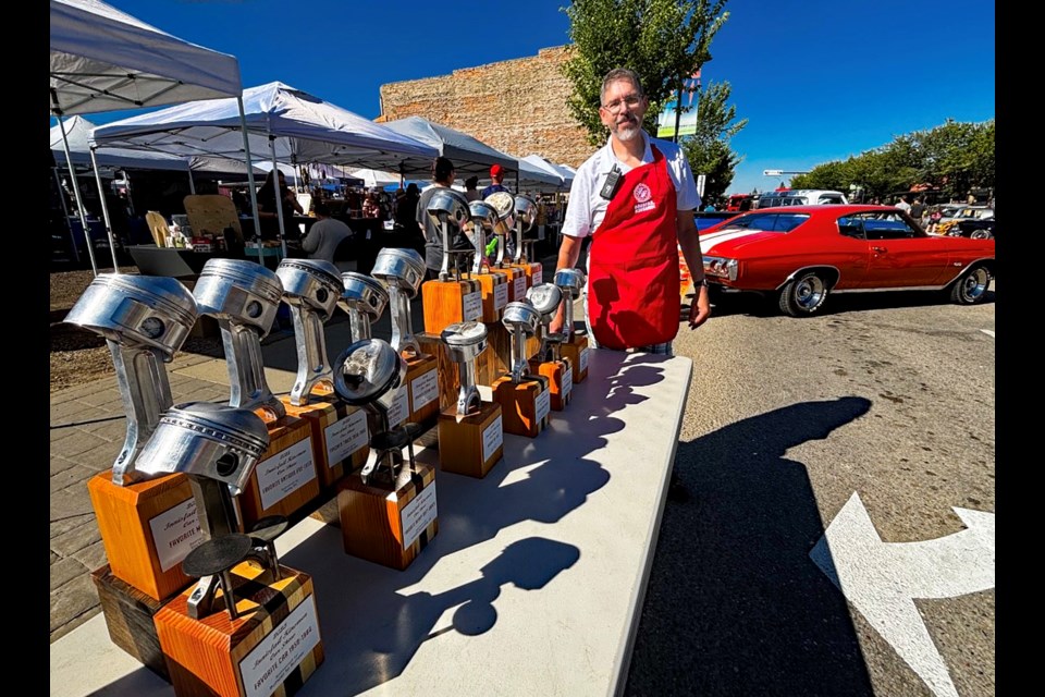 Russ Klemmer, secretary of the 2025 Innisfail Kinsmen Car Show, with his 16 handmade award trophies he made from various types of wood and donated pistons and connecting rods from different sizes of engines. Johnnie Bachusky/MVP Staff