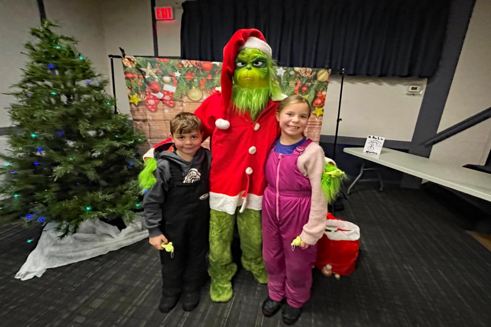 Innisfail's eight-year-old Gryffin Boyes, left, and his older sister Lilah have their photo take with the Grinch at the third annual Innisfail Grinchmas on Dec. 10 at the Royal Canadian Legion Branch #104 in Innisfail. 
Johnnie Bachusky/MVP Staff