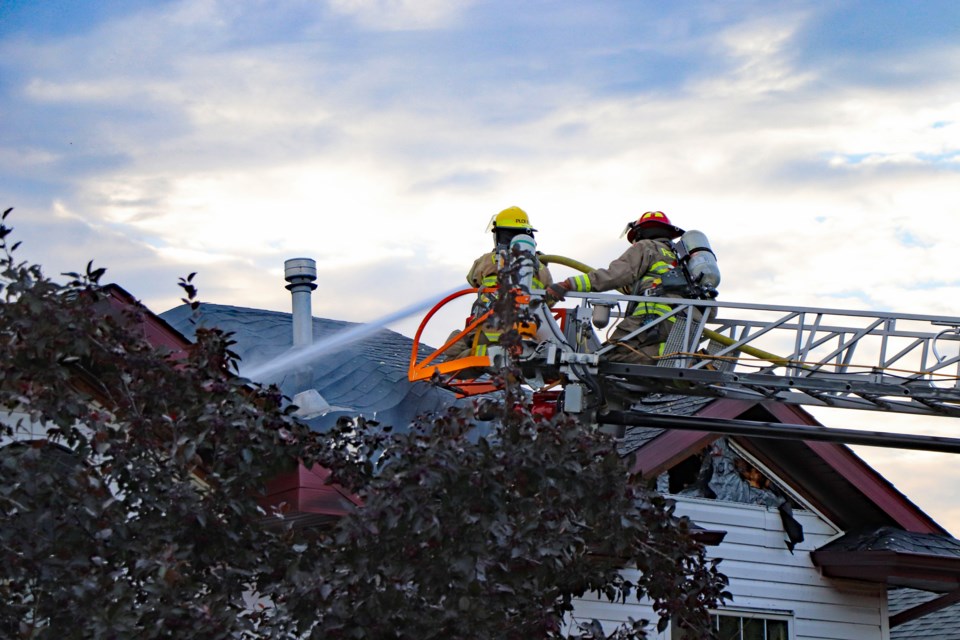 Firefighters on a ladder truck putting out roof hot spots from a house fire in Innisfail on Aug. 15 at 5230 – 41st St. Cres. 
Johnnie Bachusky/MVP Staff