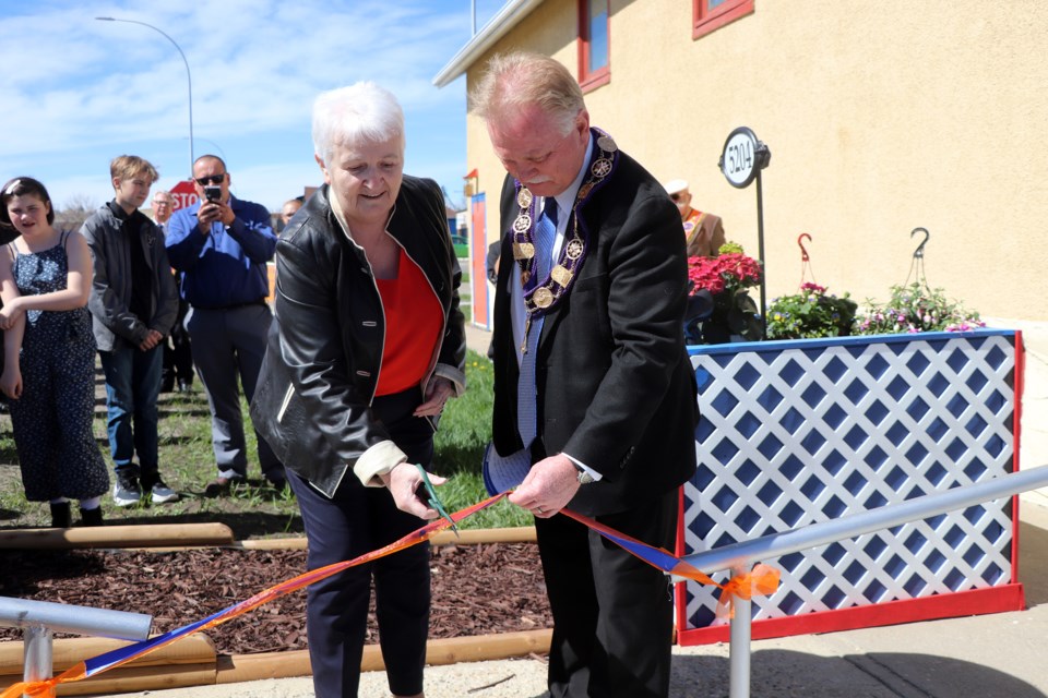 Marie Coburn, widow of the late John Coburn, cuts the ribbon on May 7 duing a dedication ceremony of a memorial garden and bench in her late husband's name. John Coburn was a long-time member of the Orange Order who passed away in 2020. Johnnie Bachusky/MVP Staff