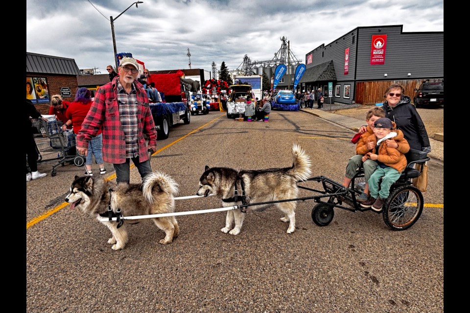 Innisfail’s Jerry Gibbons (left) is all set up to deliver a ride from his sled dogs Kayla and Miska to seven-year-old Nile Froese, his big 10-year-old brother Enver and grandmother Anita Viergutz at the Innisfail Rotary Pro Rodeo Parade. The parade was the first ever for Nile, a Red Deerian who has spinal muscular atrophy and is permanently dependent on a wheelchair for mobility. Johnnie Bachusky/MVP Staff