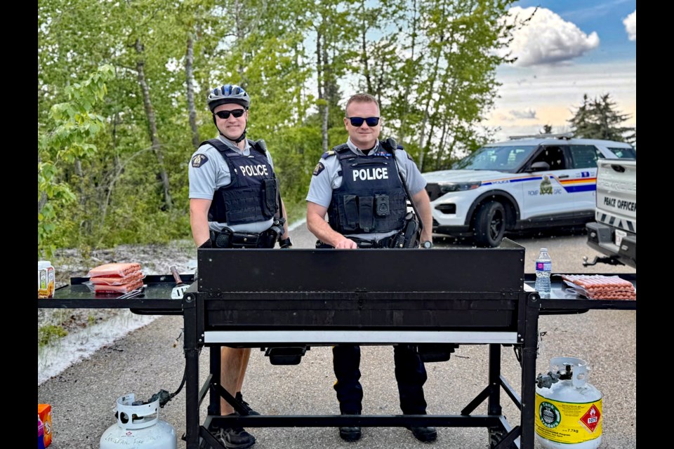 Innisfail RCMP Const. Craig Nelson (left) and Innisfail RCMP detachment commander Staff Sgt. Ian Ihme at the barbecue during the 5th annual Innisfail RCMP Bike Rodeo on May 24 in the parking lot of the Innisfail Library/Learning Centre. Submitted RCMP photo