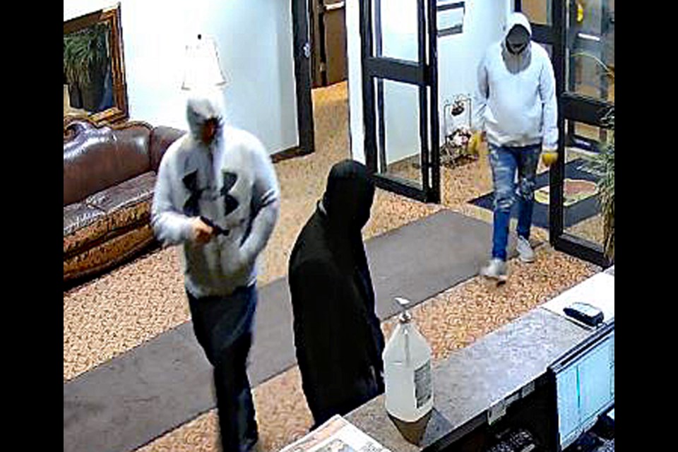 Surveillance camera still photo of three suspects in the armed robbery of Innisfail's Super 8 hotel during the early morning hours of May 29. 
Photo courtesy of RCMP
