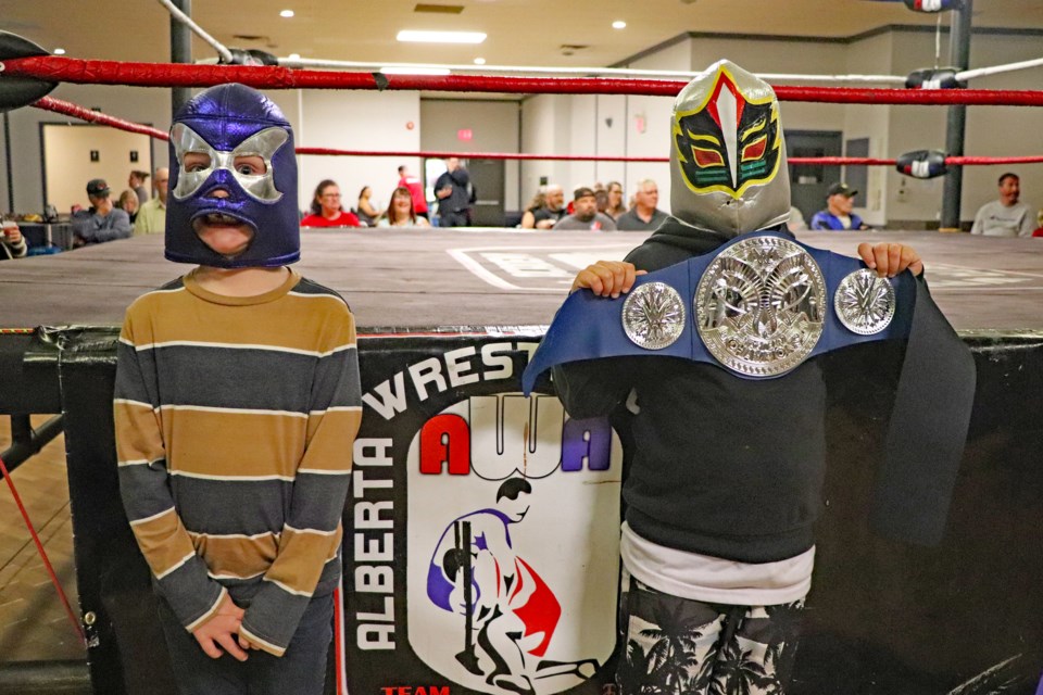 Innisfail's young enthusiastically dressed up and came out to the auditorium at the Innisfail Royal Canadian Legion Branch #104 on Sept. 17th to watch their grappling heroes. From left to right is six-year-old Stirling Turnbull and his masked, belt-carrying seven-year-old pal Mason Nafziger. Johnnie Bachusky/MVP Staff
