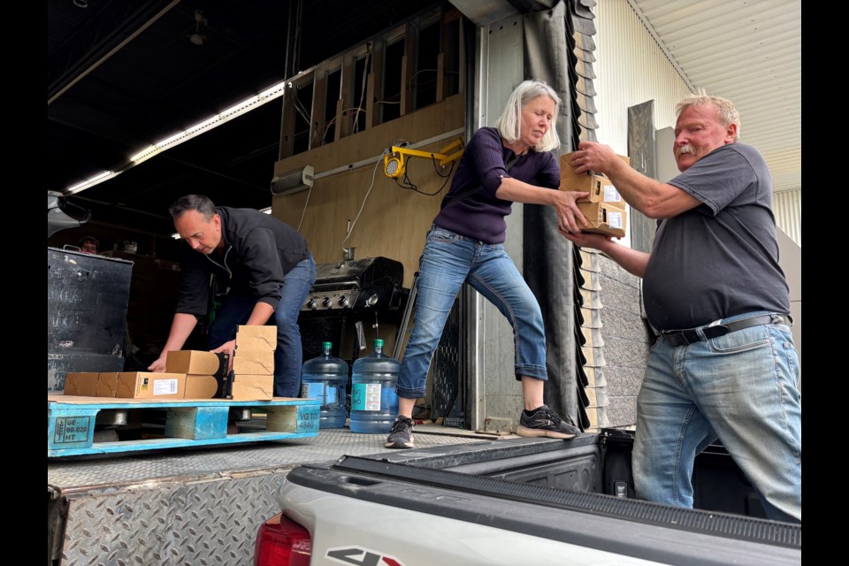 Paul Begg, owner of Paul's NoFrills Innisfail (left), helps Susan and Derek Roy load up their truck with 60 cubic feet of food and living supplies. The couple then drove 428.5 kilometres to deliver the much-needed food and supplies to Jasper citizens. Johnnie Bachusky/MVP Staff