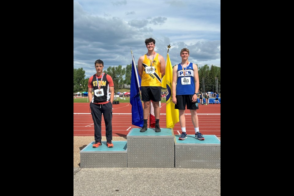 Proud ÉOHS athlete Jett Rosch stands in the top spot of the provincials podium. He won gold in senior men’s shot put and silver in senior boys discus.