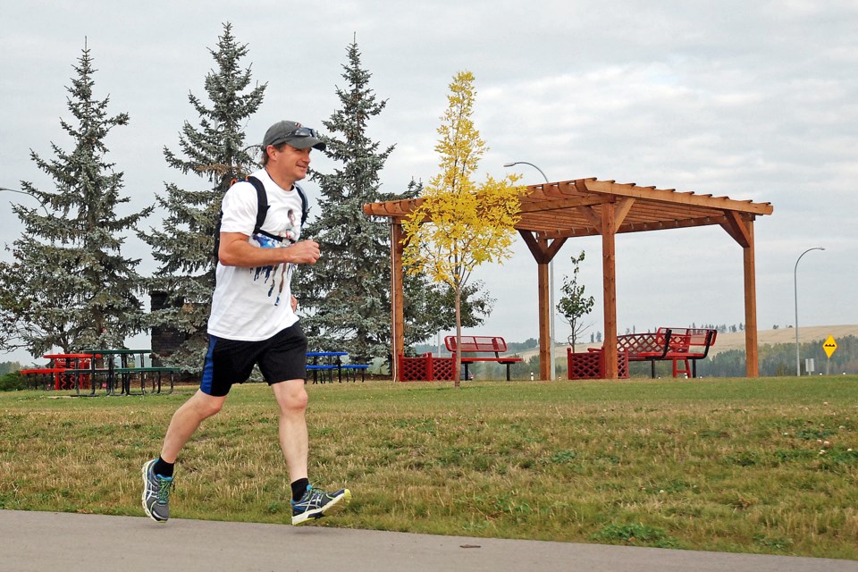 Ken Kerik jogs past the new pergola across the street from Tim Hortons in Sundre near the Highway 27/22 intersection on Sunday morning on his way to Olds for a roughly 40 km trek in recognition of the 40th annual Terry Fox Run. 
Simon Ducatel/MVP Staff