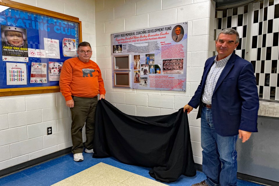 Scott (left) and David Reid, sons of the late legendary Innisfail minor hockey coach Larry Reid unveil the updated Tribute Board created for their father at a special celebration on Sept. 24th at the Innisfail Twin Arena. Johnnie Bachusky/MVP Staff