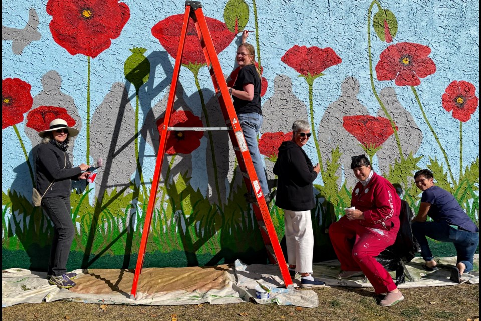 Artist Karen Scarlett and volunteers put on the finishing touches last week on a panel of the grand veterans mural on the exterior wall of the Innisfail Royal Canadian Legion Branch #104. From left to right is Carol McKinnie, past president of the Innisfail Art Club; volunteer Nina Smit, Wilma Watson, current president of the local art club; Scarlett, the project lead, and volunteer Bev Carson. Johnnie Bachusky/MVP Staff