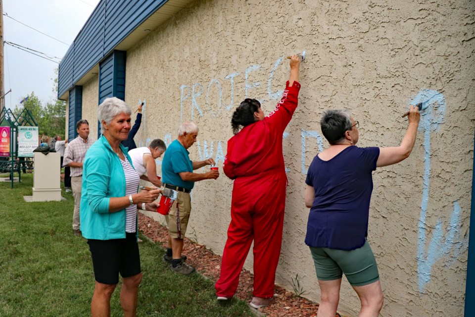 The launch on July 10 for the planned 2,074 square foot mural on the exterior south and west walls of the Innisfail Royal Canadian Legion Branch #104 attracted a score of volunteers, including members of the Innisfail Art Club. Johnnie Bachusky/MVP Staff