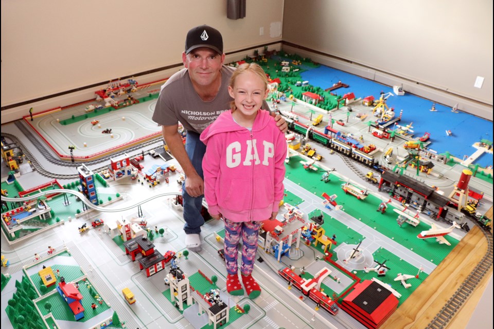 Innisfail's Dustin Smith and his seven-year-old helper Shelby MacLeod stand on a street of LEGO town that has taken a year to build. Johnnie Bachusky/MVP Staff