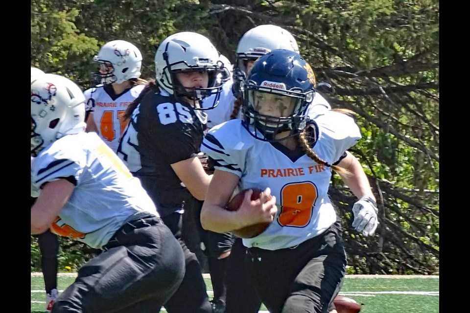 Lillian Watkinson runs with the football during a game between her Central Alberta Fire team and the Airdrie Raiders on May 14. The Fire is now in the first-ever playoffs of the new four-team U18 Female Football League. Watkinson is also preparing with her Team Alberta team for the female under-18 football national championships in Ottawa next month. Submitted photo