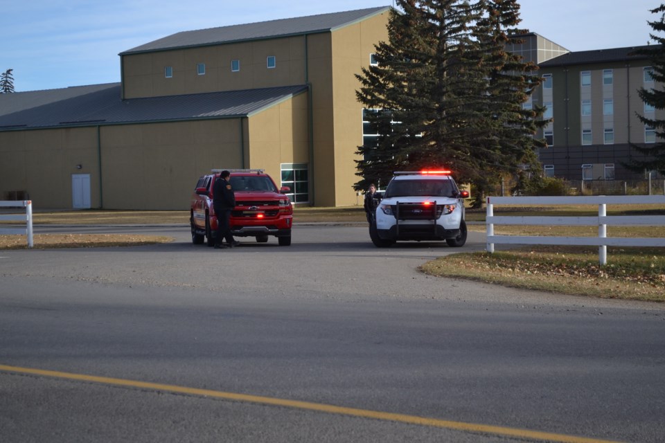 Firefighters and police parked at an entrance to the Olds College of Agriculture & Technology and Olds High School.