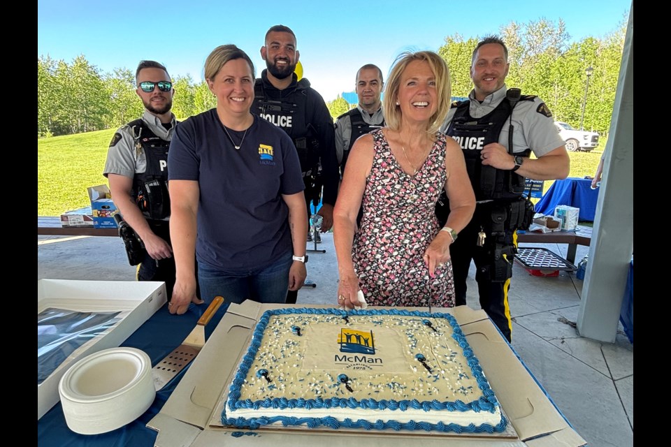 Sherri McAllister, executive director of McMan Central, cuts an anniversary cake on May 28 at Innisfail's Centennial Park to honour the 50-year service of McMan Youth, Family and Community Services Association for its essential work in Alberta communities. Johnnie Bachusky/MVP Staff