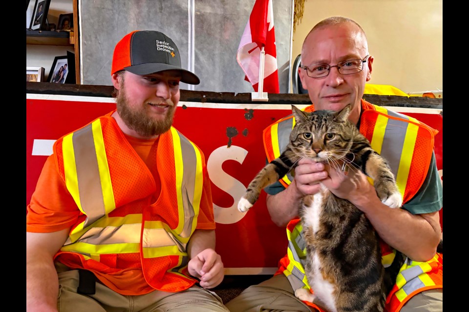 Innisfailian John Smith, right, with kitty Merlin as son Zach looks on. Merlin is their training aid specialist for their future volunteer work to find missing people. Johnnie Bachusky/MVP Staff