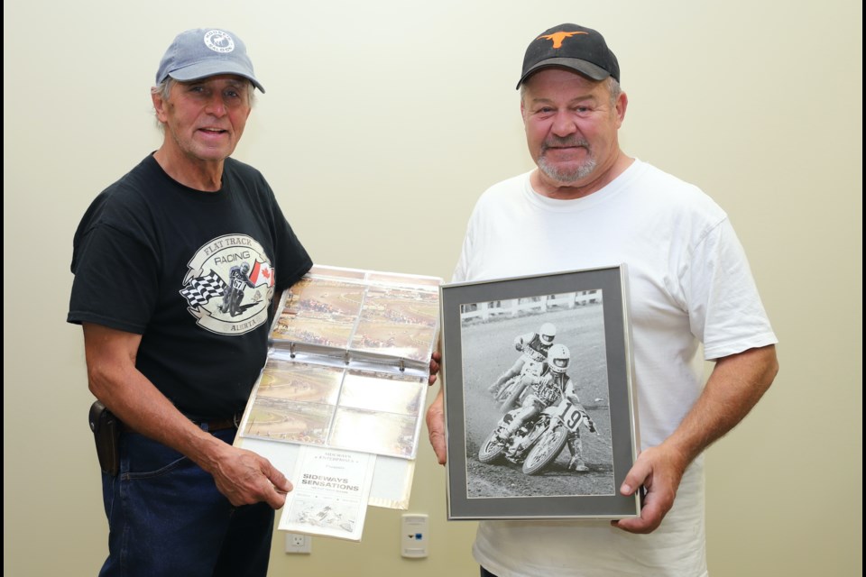 Darrell MacRae, left and George Wells hold mementos from their motorbike racing days at olds and over the years.
