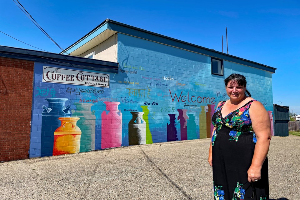 Calgary artist and former Innisfailian Karen Scarlett at the site of the nearly completed Welcome Mural on the south wall of The Coffee Cottage in downtown Innisfail. She said about 60 volunteers have helped with the public art project. She said the mural could be completed this week. 
Johnnie Bachusky/MVP Staff