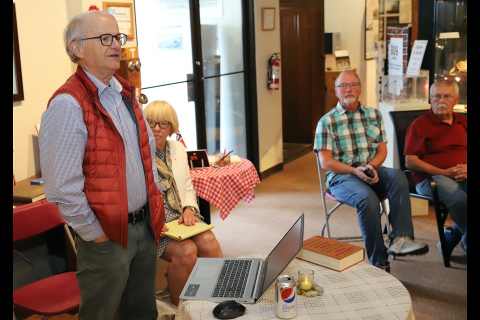 Norwegian professor emeritus Gunner Tore Nerheim tells attendees at a traditional Norwegian coffee party in the Mountain View Museum & Archives about his tour to collect information and stories about Norwegian settlers in the area for his website. Looking on at left is his wife, Inger Kari Nerheim.