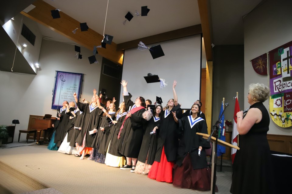 As principal Cherie Sanche watches,Olds Koinonia Christian School grads toss their caps at the conclusion of their graduation ceremony June 8 in the First Baptist Church Olds.
Doug Collie/MVP Staff