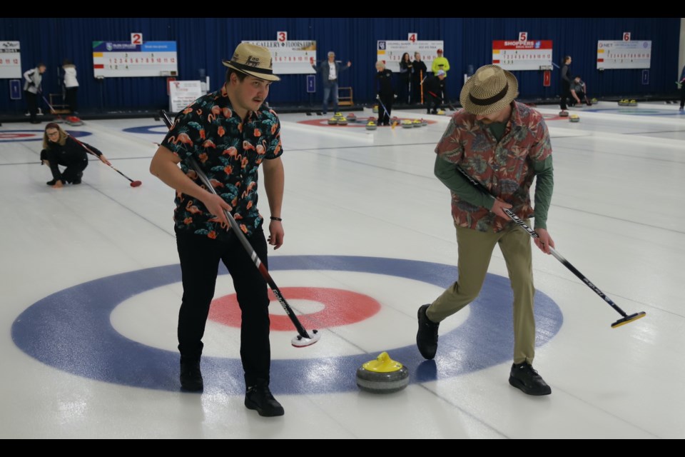 Jacquie Vammen, left, background, watches as Reed and Ryan Vammen guide a rock she threw during the Open Bonspiel, held March 22-24 at the Olds Curling Club.