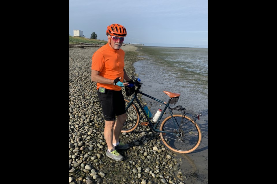 Sundre resident Phil Meagher, who early on in life developed a passion for cycling, gets his back tire wet in the Pacific on June 15 before embarking on his bucket list trip to bike across the country.