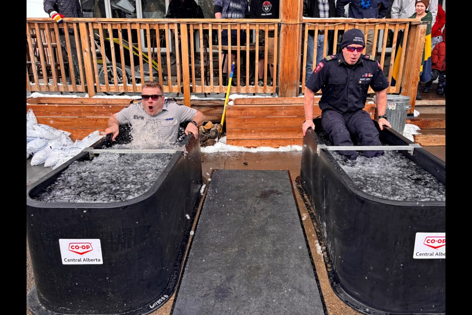 Innisfail RCMP Staff Sgt. Ian Ihme, left, and Innisfail Fire Department Chief Gary Leith brave the prolonged cold weather conditions on March 23 to take the plunge at the annual Polar Plunge event in downtown Innisfail. 
Johnnie Bachusky/MVP Staff
