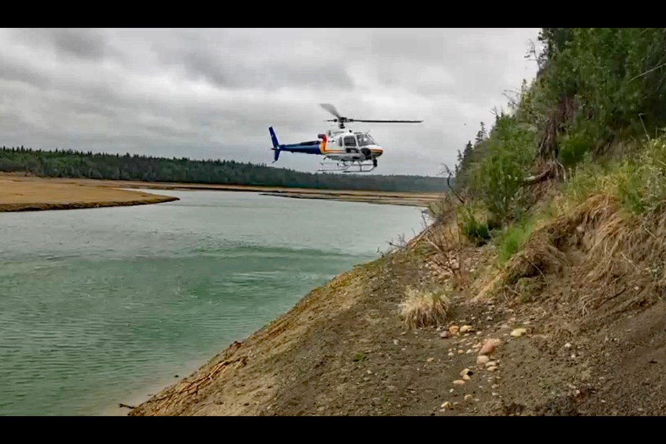 A helicopter with an Alberta RCMP Air Services crew moves toward missing Didsbury elderly woman Lorraine Vandenbosch who was trapped on a steep embankment at Gleniffer Lake. She had been missing for three days. 
Photo courtesy of Innisfail RCMP