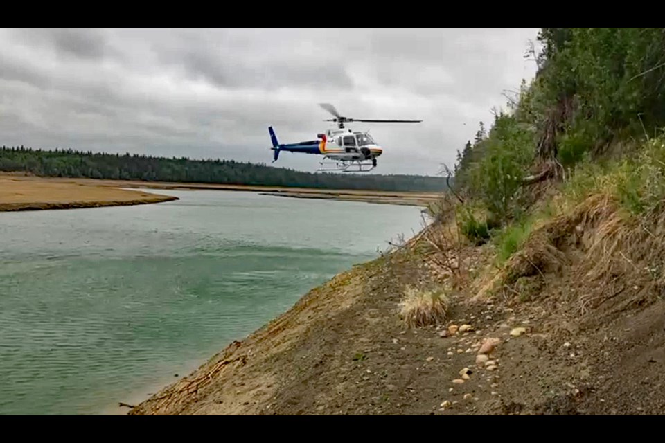 A helicopter with an Alberta RCMP Air Services crew moves toward missing Didsbury elderly woman Lorraine Vandenbosch who was trapped on a steep embankment at Gleniffer Lake. She had been missing for three days. 
Photo courtesy of Innisfail RCMP