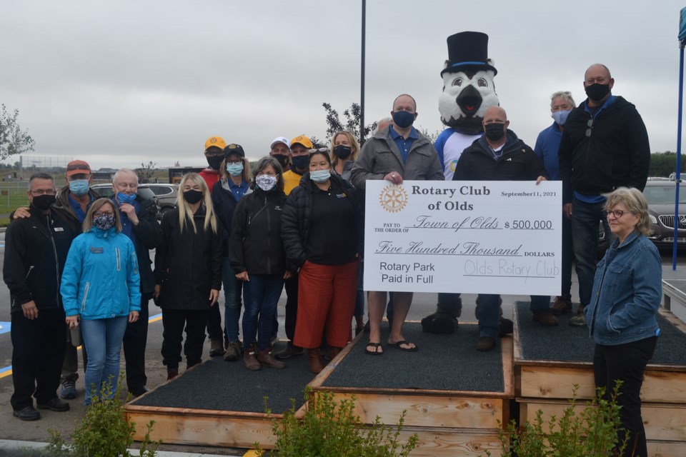 Current Rotary Club of Olds president Paul Gustafson, left, presents the club's cheque for $500,000 to Town of Olds Mayor Mike Muzychka as club members, town councillors and others look on.
Doug Collie/MVP Staff